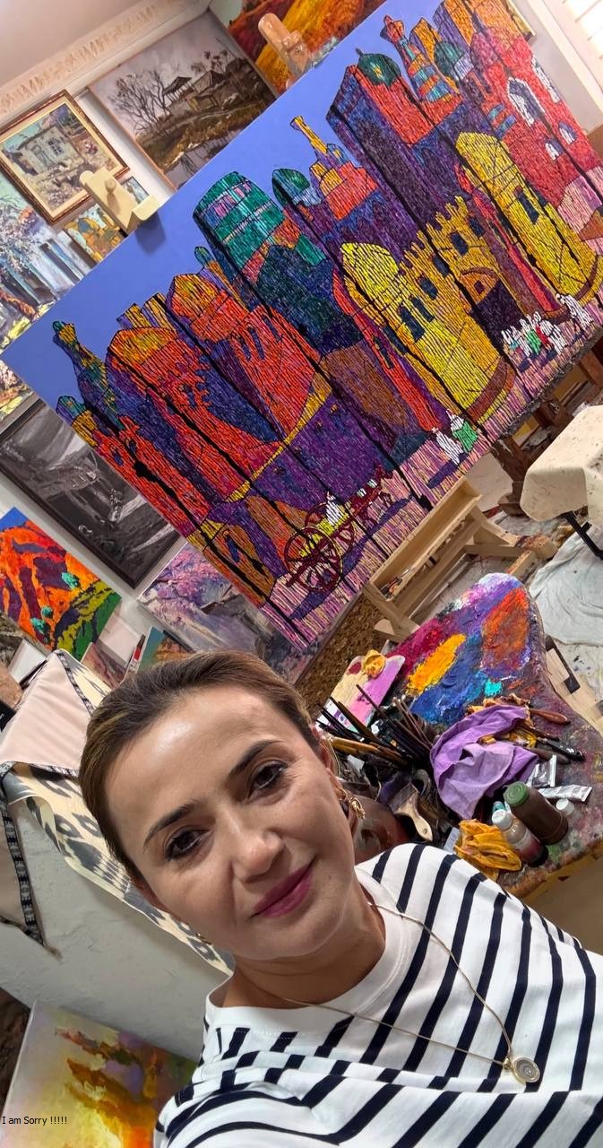 Dilorom Mamedova in her studio with a colorful architectural painting